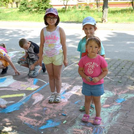 Dziewczynki stoją na namalowanym na chodniku obrazku