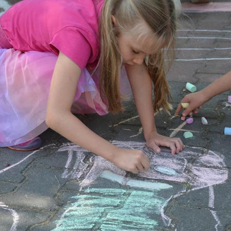 Dziewczynka maluje postać kredą