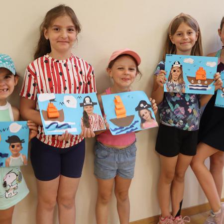 Grupa dziewczynek pokazuje własnoręcznie wykonane rysunki