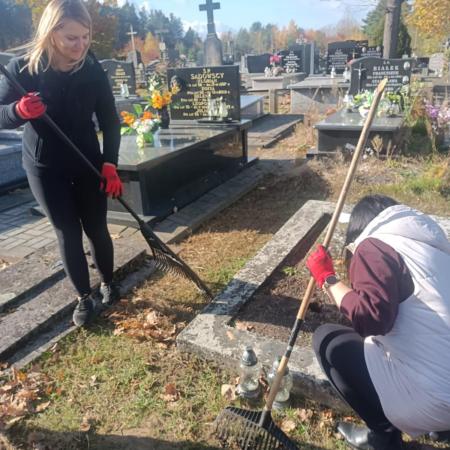 Dwie kobiety sprzątają grób na cmentarzu w Drzewicy