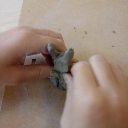 Ręce dziecka modelujące figurkę z gliny