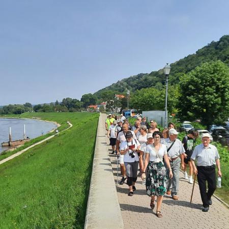 Grupa osób spacerująca wzdłuż rzeki