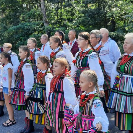 Grupa osób w ludowych strojach śpiewa na konkursie w Piotrkowie Trybunalskim