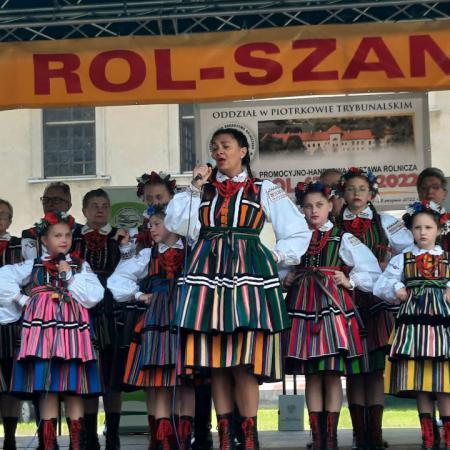 Kobieta wraz z zespołem Drzewiczanie  w ludowych strojach śpiewają podczas konkursu Roll Szansa w Piotrkowie Trybunalskim