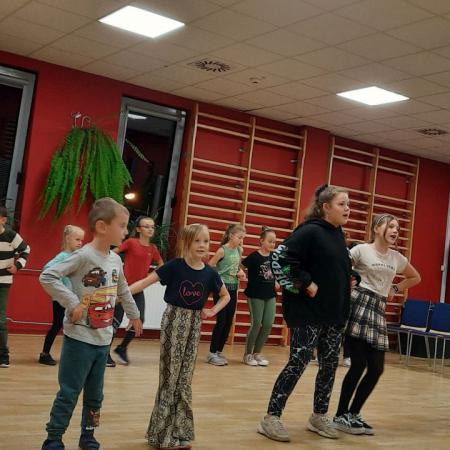 Dzieci na próbie z zajęć ludowych uczą się tańca