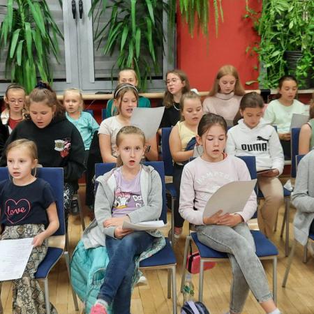 Grupa dzieci ucząca się śpiewać piosenek ludowych podczas zajęć