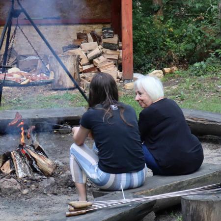 Dwie kobiety siedzą przy ognisku i rozmawiają