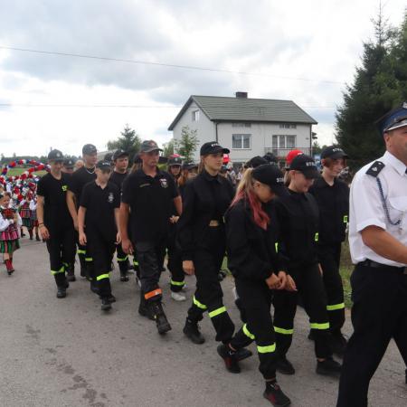 Strażacy w mundurach bojowych podczas pochodu dożynkowego w Jelni