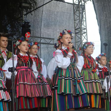 Mali Drzewiczanie w ludowych strojach śpiewają na scenie podczas Dożynek