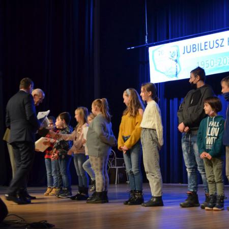 Burmistrz Drzewicy i Prezes Koła łowieckiego wręczają dyplomy dzieciom