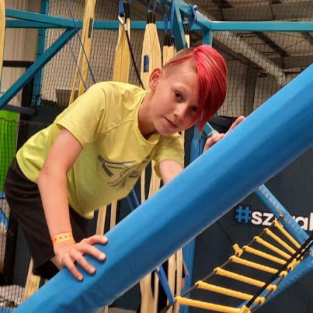 Chłopiec z czerwonymi włosami w parku trampolin