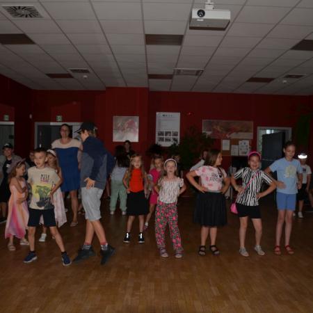 Grupa dzieci tańczy w sali tanecznej