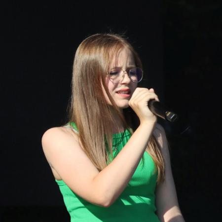 Dziewczyna śpiewa przy mikrofonie na scenie