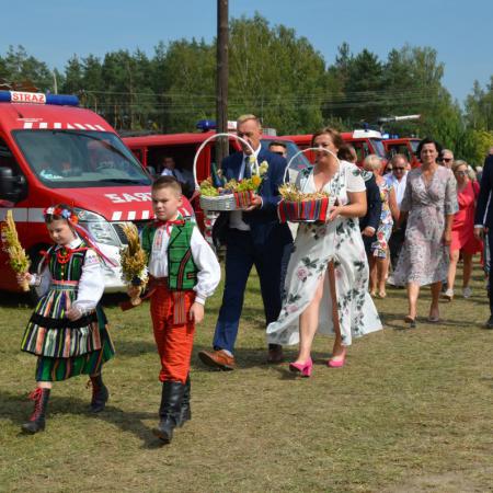 Plony dożynkowe niesione przez dzieci i starostów dożynkowych.