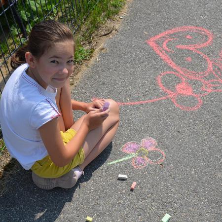 Dziewczynka maluje kwiaty kredami