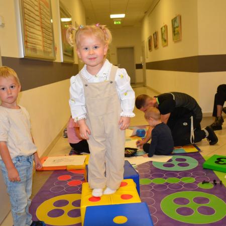 Dziewczynka stoi na kostce do zabawy.