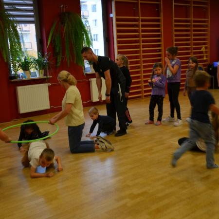 Rodzice wraz z dziećmi w trakcie zabawy podczas pikniku.