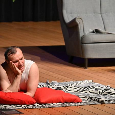 Aktor leżący na kocu odgrywa rolę marzyciela.