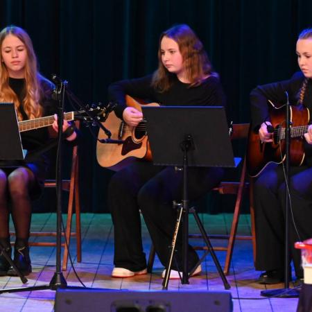 Artystki wykonują utwór grając na gitarach