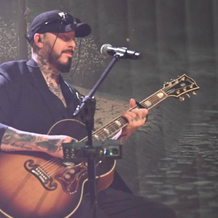 Muzyk z gitarą śpiewa do mikrofonu