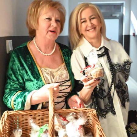 Dwie kobiety uśmiechają się, jedna z nich trzyma kosz z wypiekam