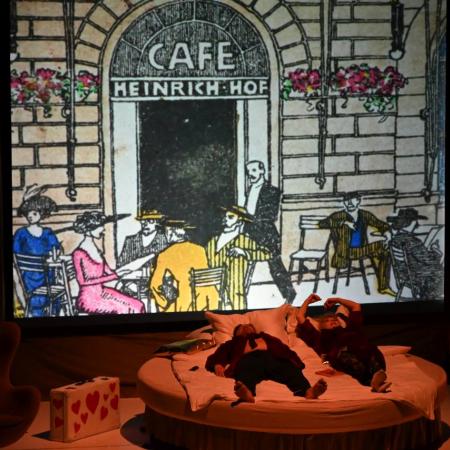 Scena w której aktorzy leżą na łóżku.