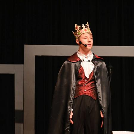 Chłopiec w roli małego księcia na scenie.