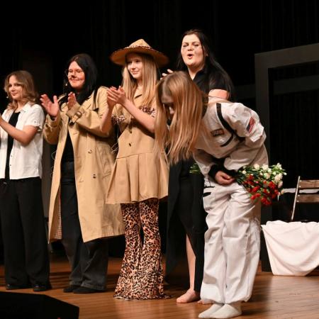 Aktorzy na scenie kłaniają się widowni.