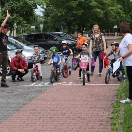 Dzieci na rowerach stoją na lini start.