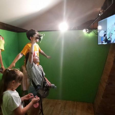 Dzieci w Muzeum kinematografii ogladają bajkę w telewizorze