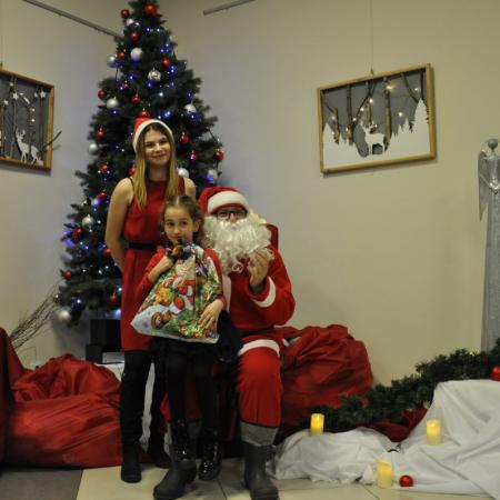 Dziewczynka trzymająca prezent z Mikołajem i Snieżynką