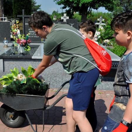 Grupa dzieci przewozi zebrane odpady w taczkach