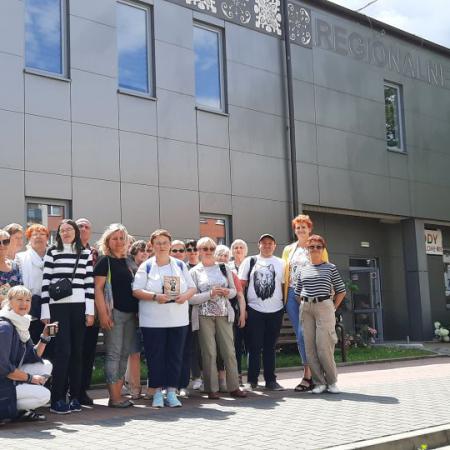 Grupa ludzi wraz z Dyrektor RCK w grupowym zdjęciu przed budynkiem Regionalnego Centrum Kultury w Drzewicy