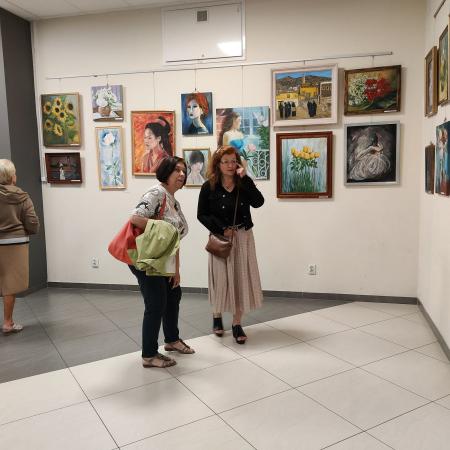 Dwie kobiety oglądają wystawę na korytarzu w RCK