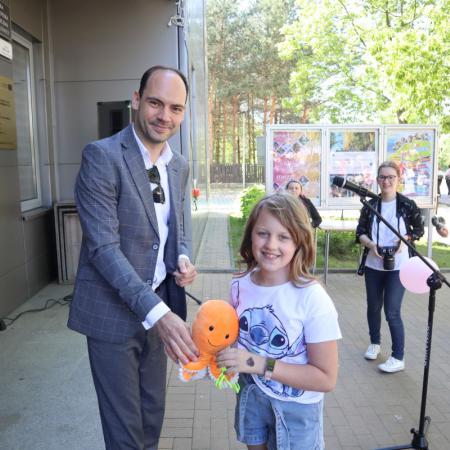 Burmistrz wręcza nagrodę dziewczynce 