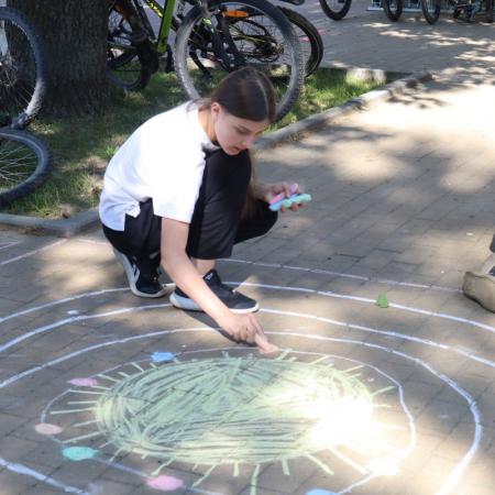 Dziewczynka maluje kredą po chodniku