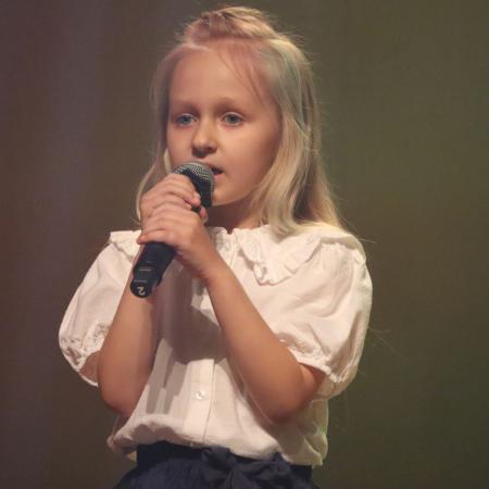 Dziewczynka śpiewa przy mikrofonie na scenie