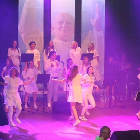 Grupa osób tańczy na scenie podczas Koncertu Uwielbienia