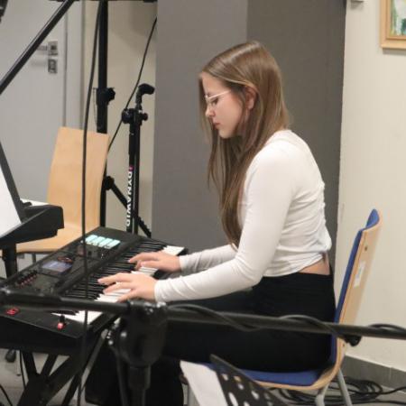 Uczestniczka zajęć muzycznych gra na keyboardzie