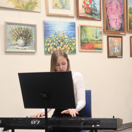 Uczestniczka zajęć muzycznych gra na keyboardzie