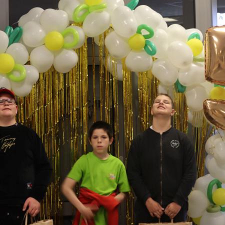 Dzieci stoją przy ściance z balonami