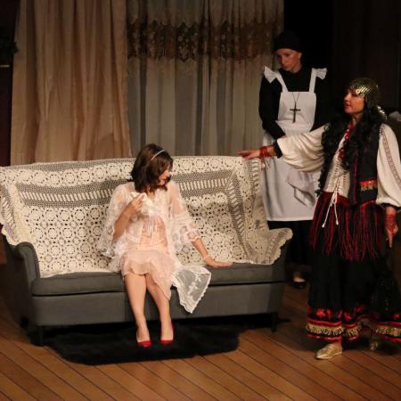 Kobiety występują na scenie podczas sztuki "Czapka Błazeńska" 