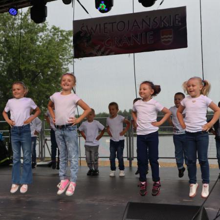 Grupa dzieci tańczy na scenie 