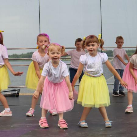 Dzieci w kolorowych spódniczkach występują na scenie podczas Sobótki