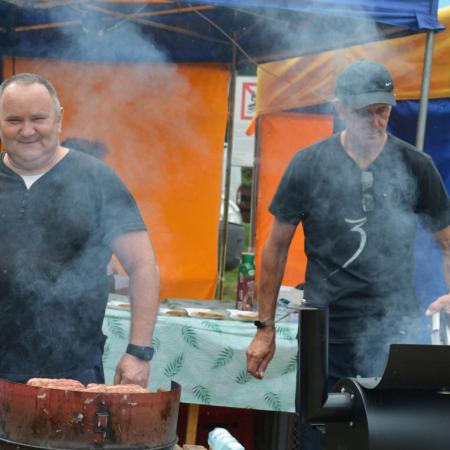 Dwaj mężczyźni grillują kiełbaski na Sobótce 
