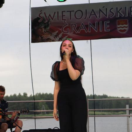 Kobieta śpiewa przy mikrofonie na scenie