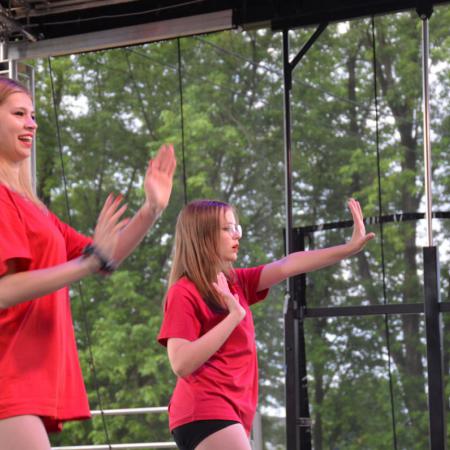 Dziewczyny w czerwonych koszulkach tańczą na scenie podczas Sobótki