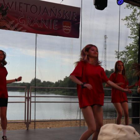 Dziewczyny w czerwonych koszulkach tańczą na scenie