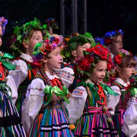 Mali Drzewiczanie w ludowych strojach śpiewają na scenie 