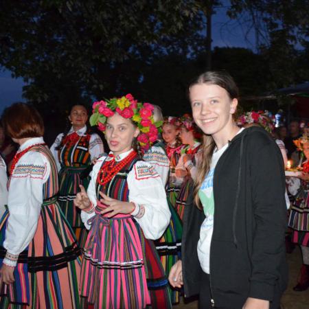 Grupa osób idzie puszczać wianki nad zalew